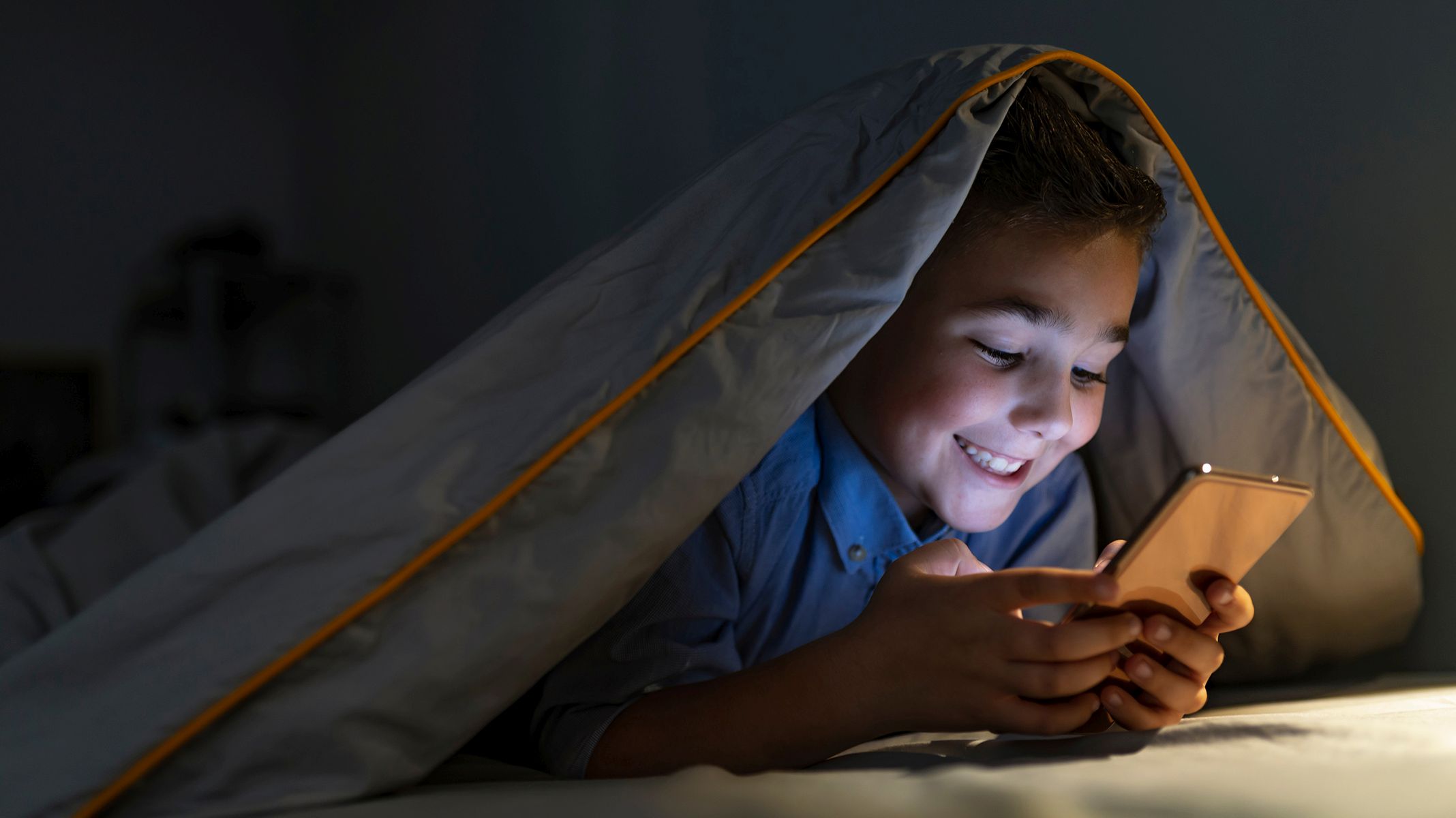 Играть в телефоне ночью. Ребенок под одеялом. Ребенок со смартфоном. Мальчик под одеялом с телефоном.
